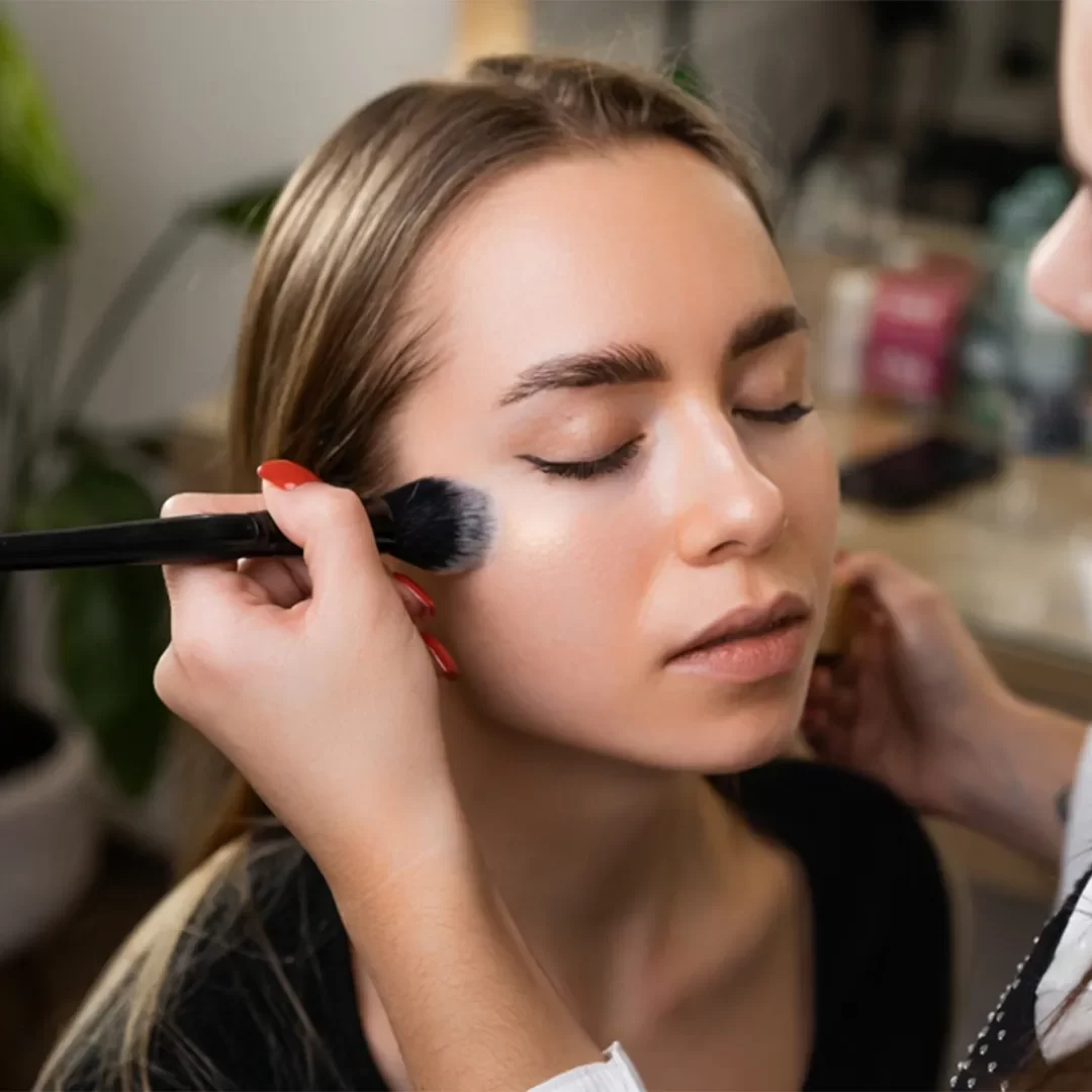 Professional makeup artist applying flawless makeup at home